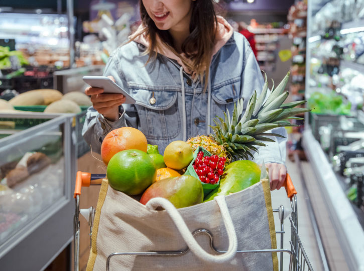 mujer joven compra alimentos supermercado telefono mano